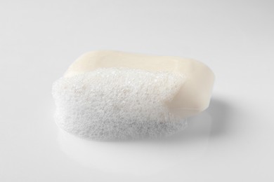 Photo of Soap with fluffy foam on white background