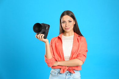 Photo of Professional photographer working on light blue background in studio