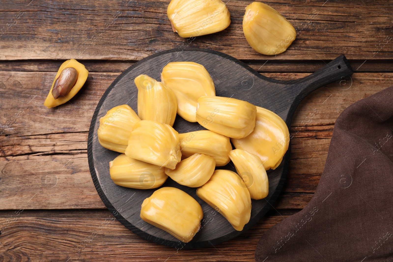 Photo of Delicious exotic jackfruit bulbs on wooden table, flat lay