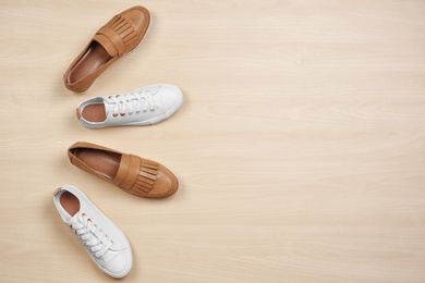 Photo of Different female shoes on wooden background