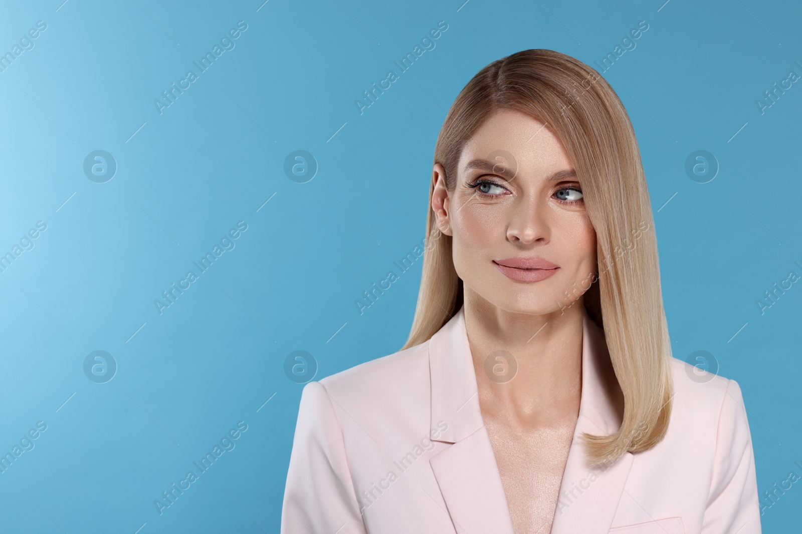 Image of Portrait of stylish attractive woman with blonde hair on light blue background, space for text