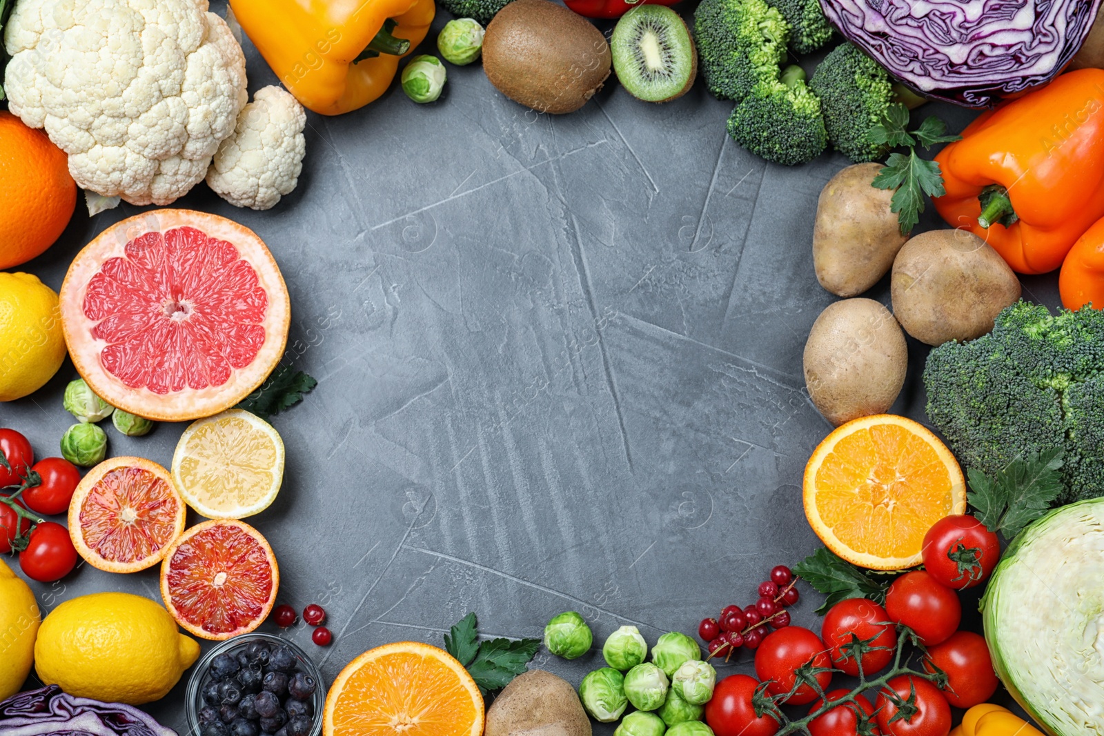 Photo of Different products rich in vitamin C on grey table, flat lay. Space for text