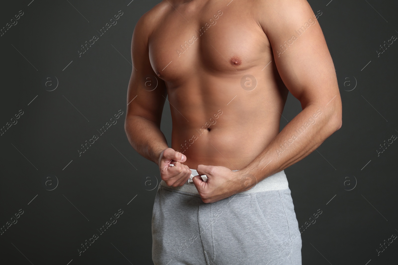 Photo of Man with sexy body on grey background, closeup