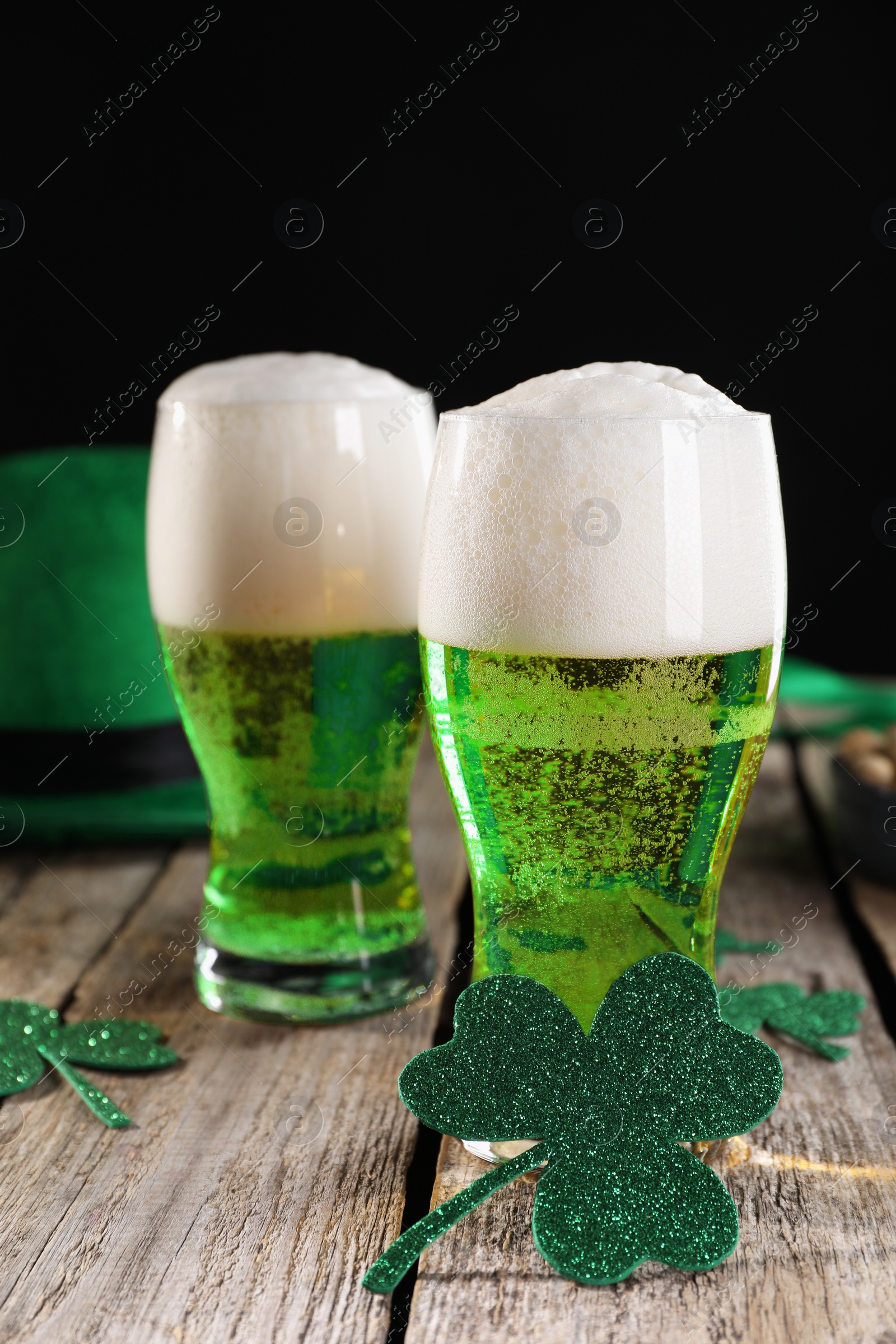 Photo of St. Patrick's day party. Green beer and decorative clover leaves on wooden table