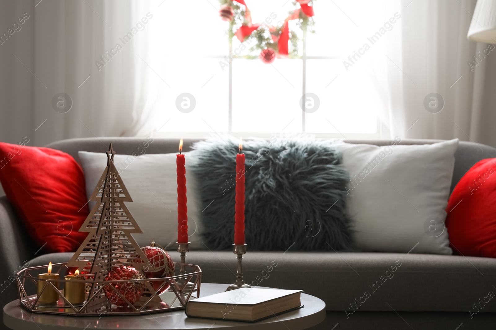 Image of Christmas decor with candles on table in living room. Festive interior