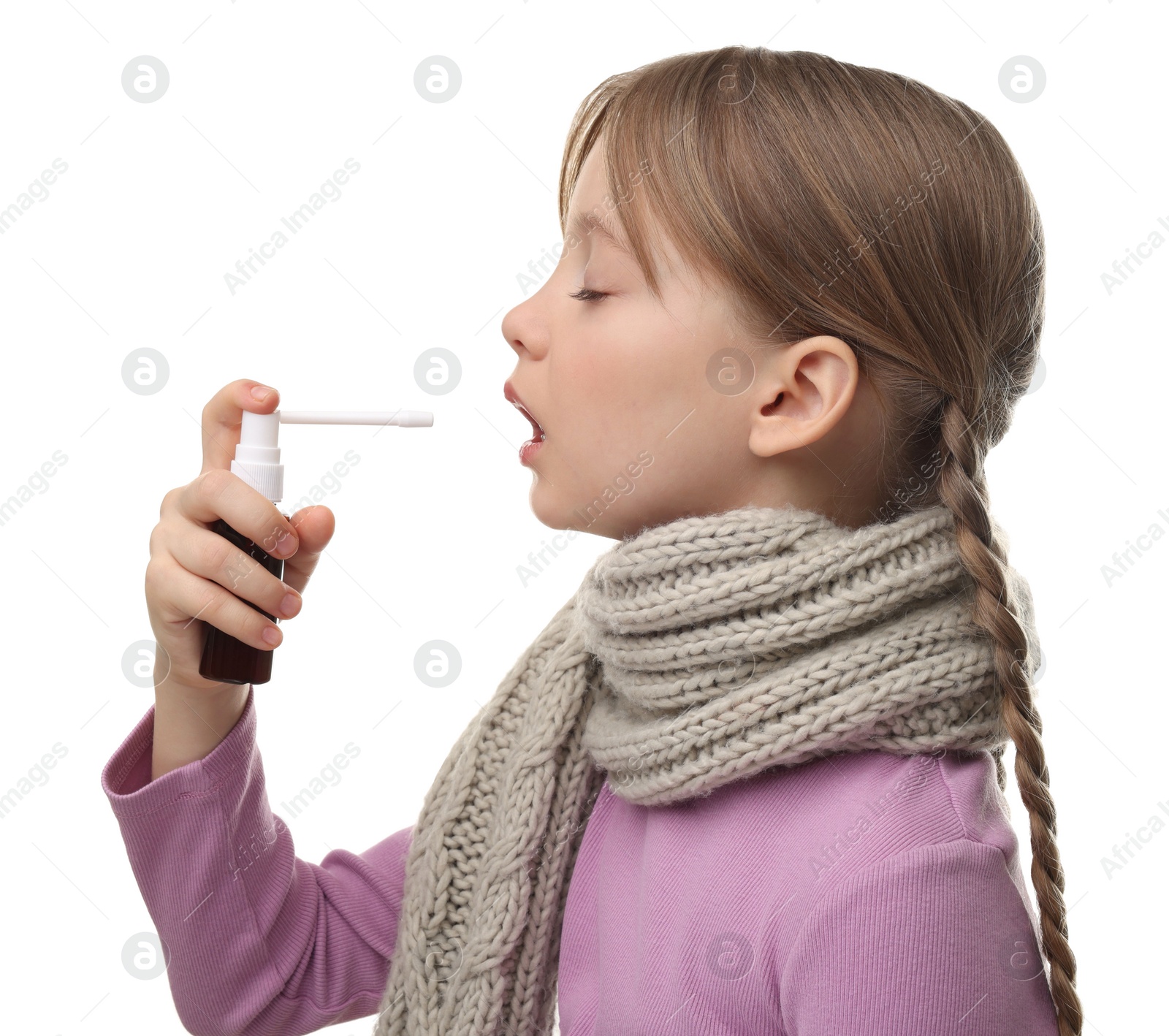 Photo of Little girl with scarf using throat spray on white background