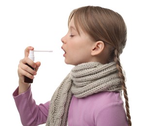 Little girl with scarf using throat spray on white background