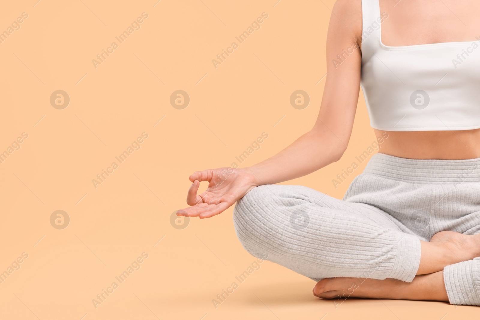 Photo of Woman practicing yoga on beige background, closeup and space for text. Lotus pose