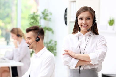 Photo of Young female receptionist with headset in office