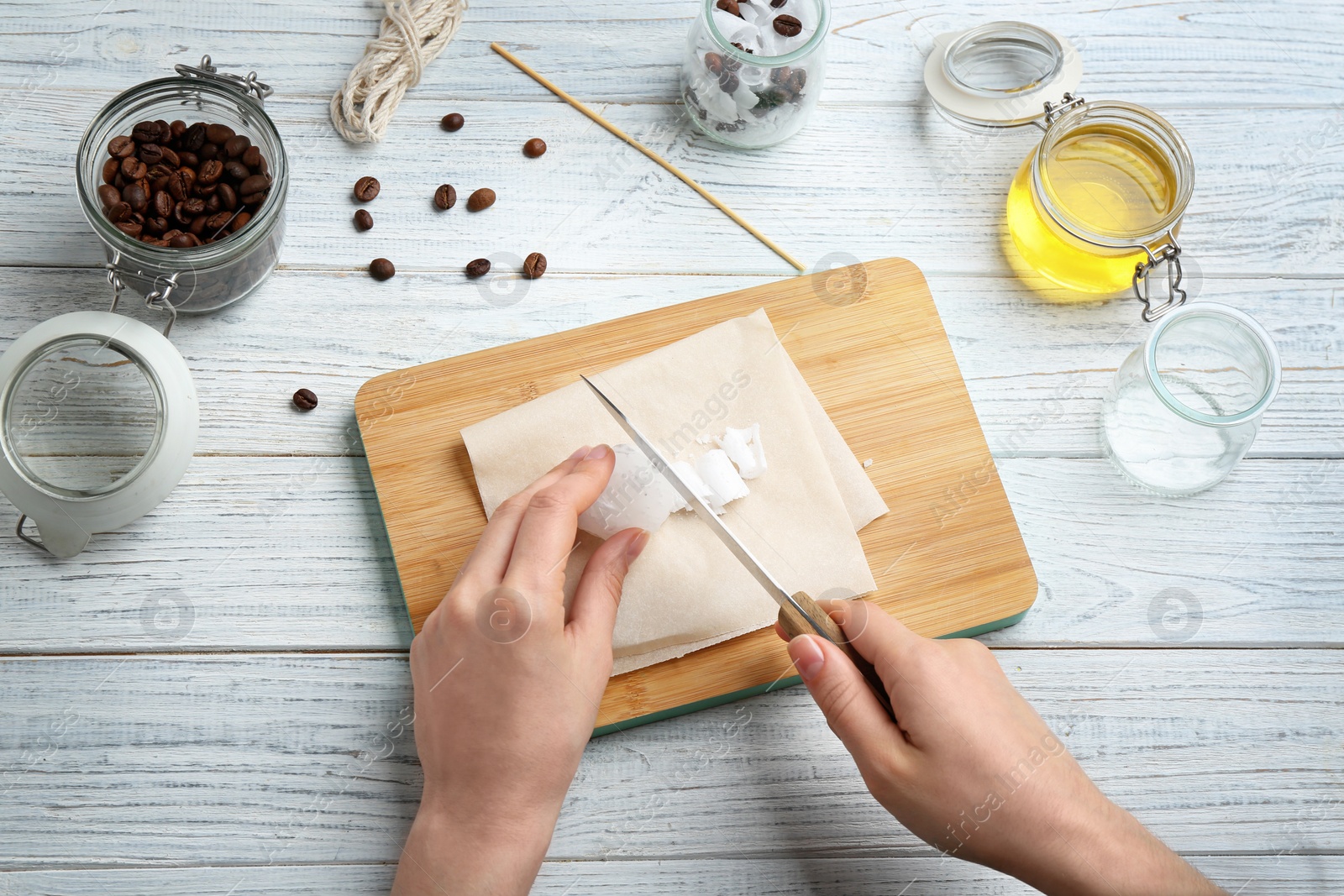 Photo of Woman making coffee candle at wooden table, closeup