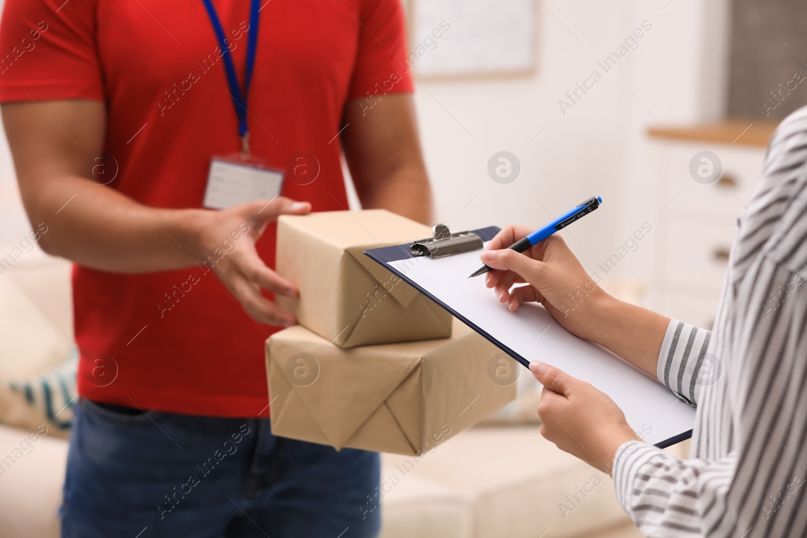 Photo of Woman signing for delivered parcels at home, closeup. Courier service