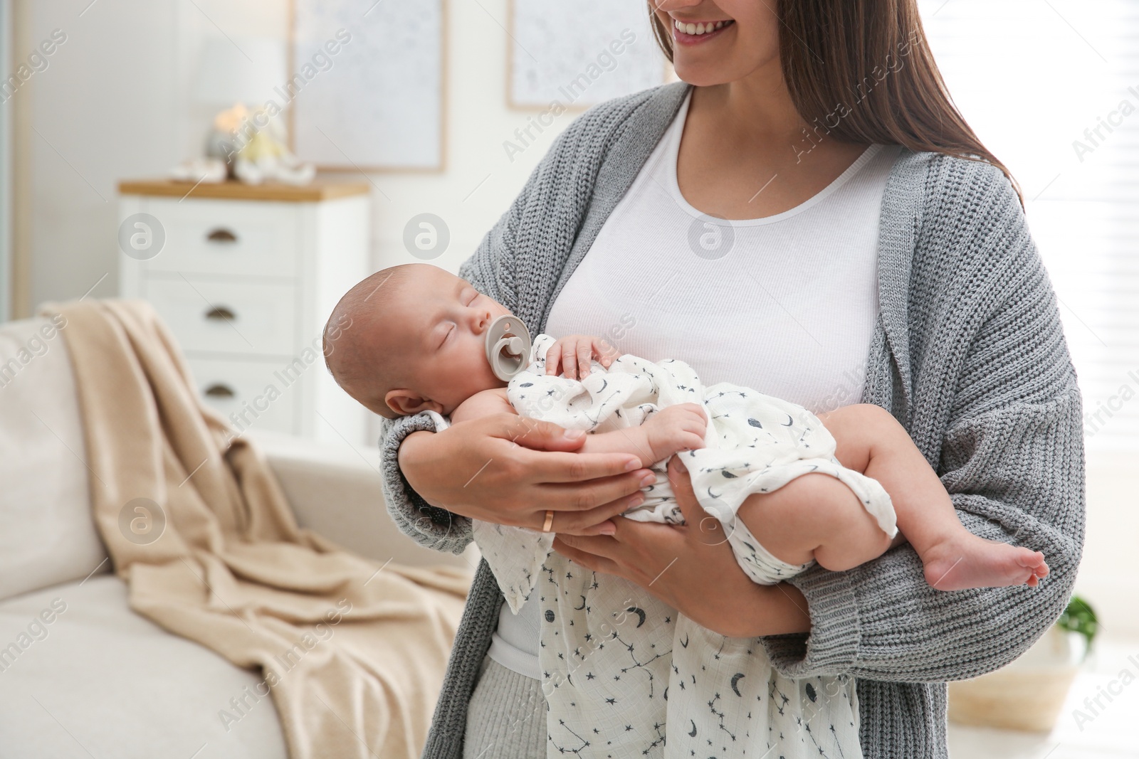 Photo of Mother holding her sleeping baby at home, closeup