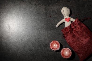 Photo of Voodoo doll pierced with pins and candles on grey table, flat lay. Space for text