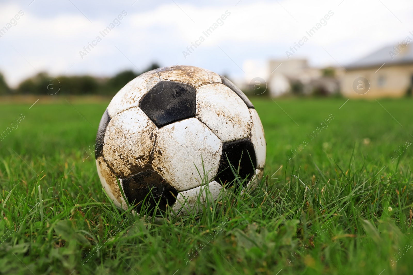 Photo of Dirty soccer ball on green grass outdoors, space for text