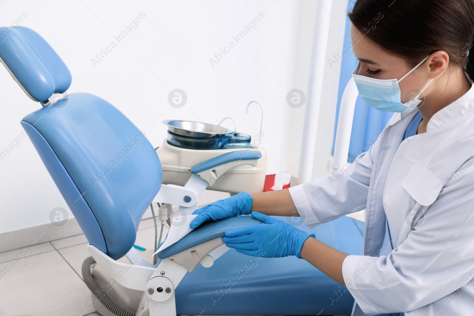 Photo of Professional dentist in white coat cleaning workplace  indoors