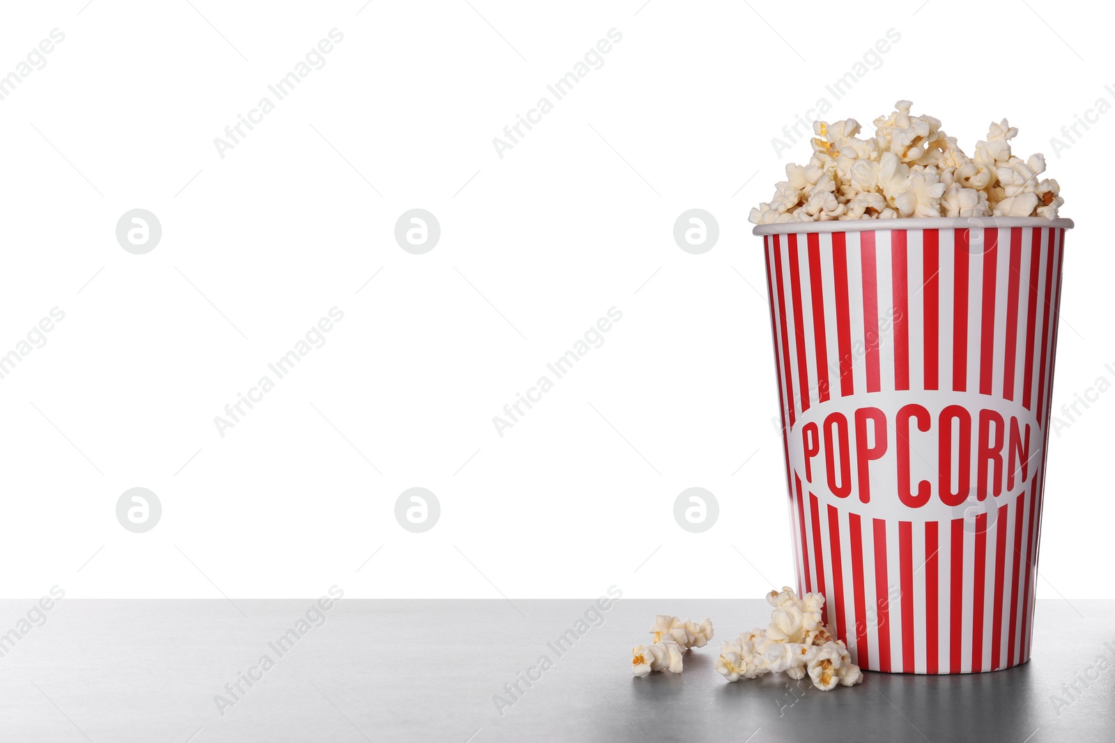 Photo of Delicious popcorn on grey table against white background
