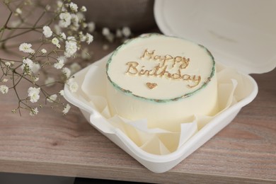 Delicious decorated Birthday cake and dry flowers e on wooden surface indoors