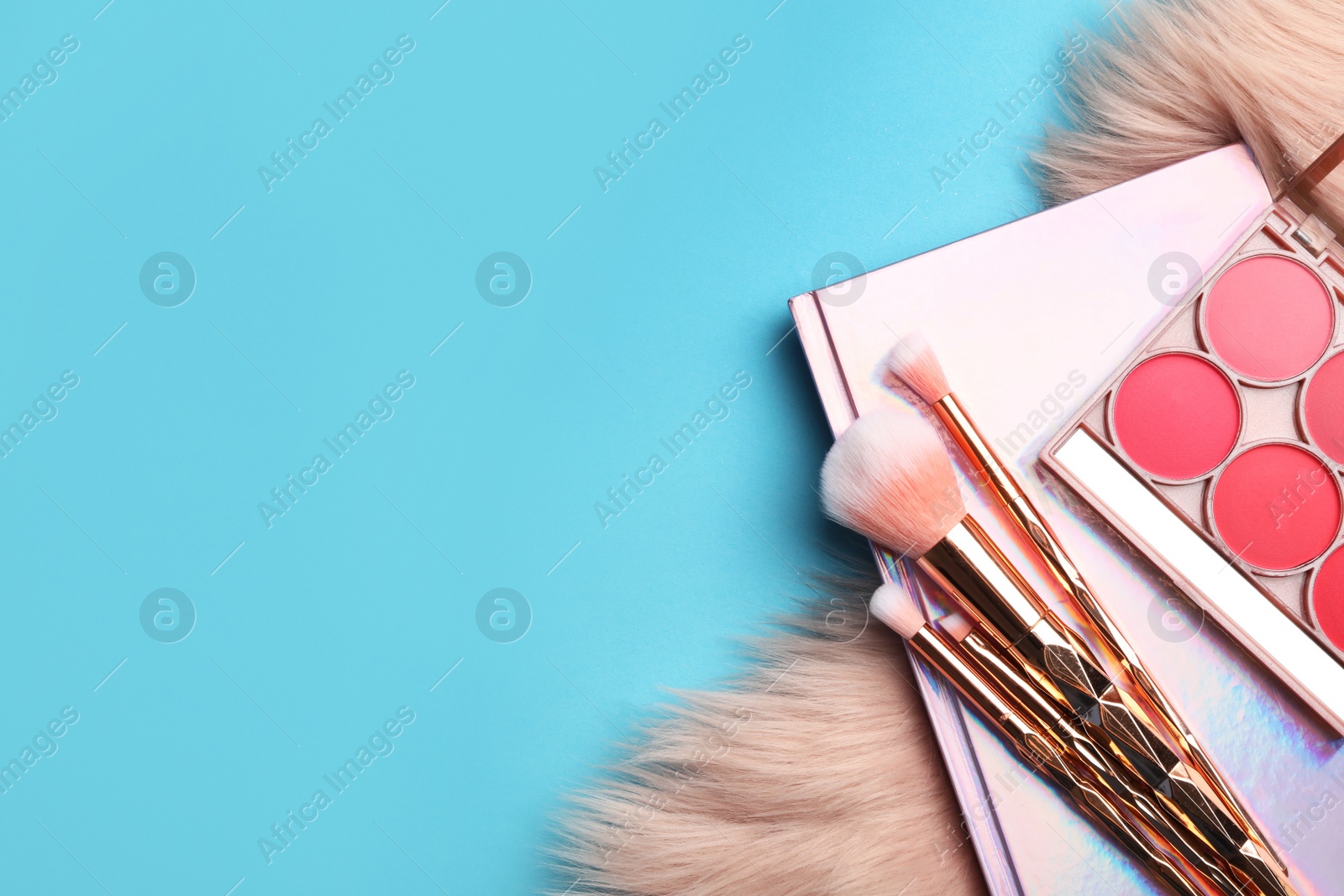 Photo of Flat lay composition with coral cosmetics and fur on light blue background. Space for text