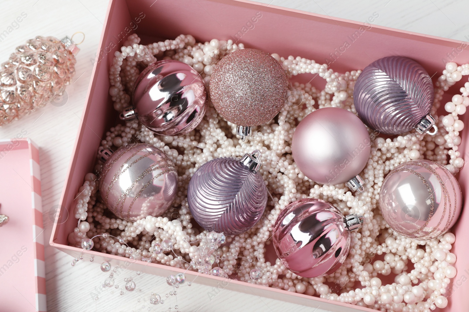Photo of Beautiful Christmas baubles on white wooden table, above view