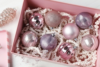 Photo of Beautiful Christmas baubles on white wooden table, above view