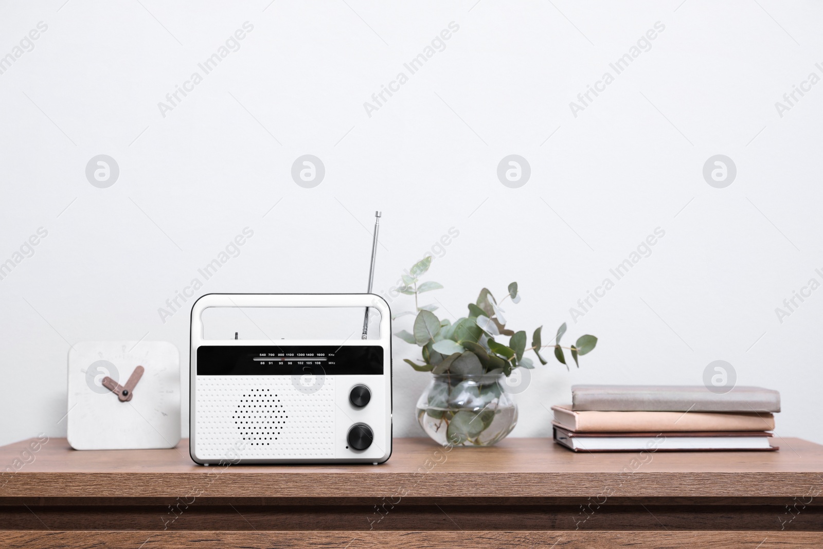 Photo of Stylish radio and interior elements on wooden table near white wall indoors. Space for text