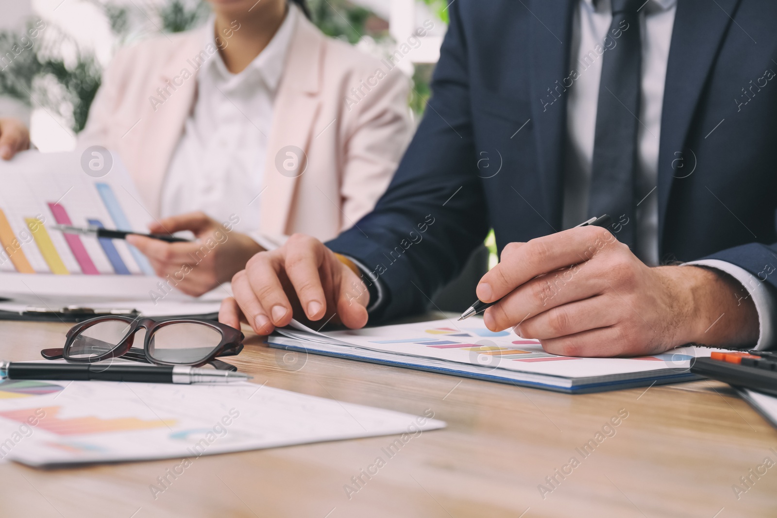 Photo of Business people working with charts and graphs at table in office, closeup. Investment analysis