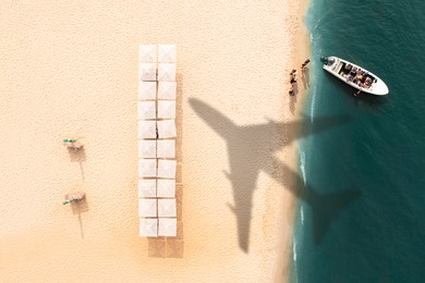 Image of Shadow of airplane and motorboat with people at sandy coast, aerial view. Summer vacation