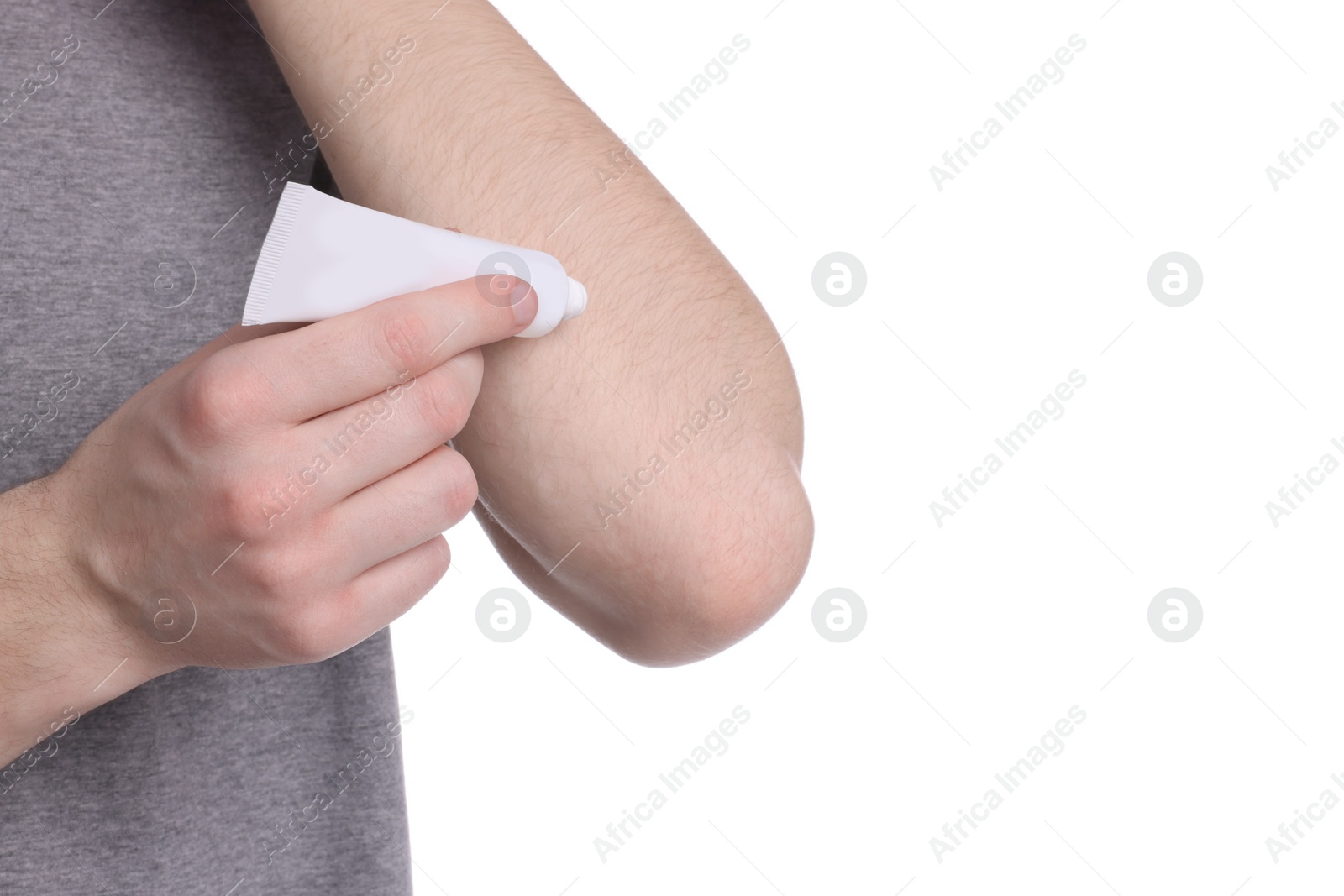 Photo of Man applying ointment from tube onto his arm on white background, closeup