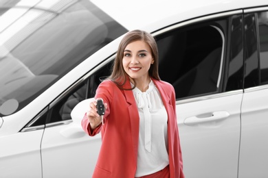 Young woman holding car key in salon