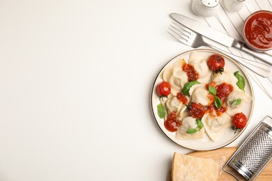 Photo of Tasty ravioli with tomato sauce served on white table, flat lay. Space for text