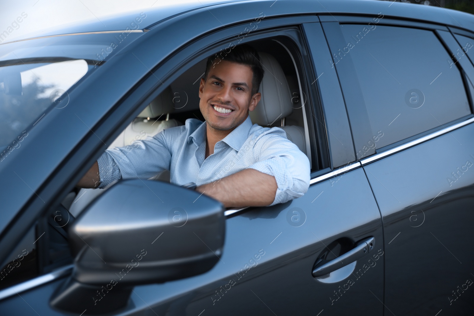 Photo of Handsome man in his modern car, view from outside