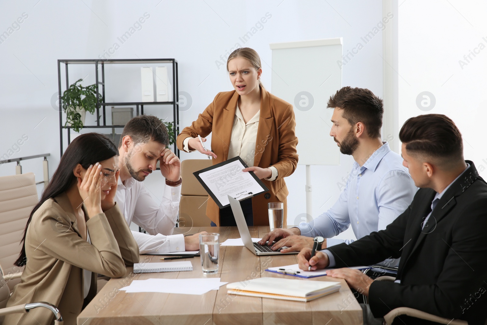 Photo of Boss screaming at employees in office. Toxic work environment