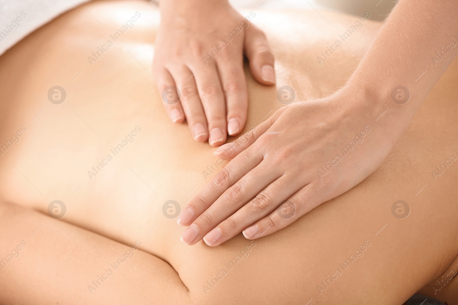 Photo of Relaxed woman receiving back massage in wellness center