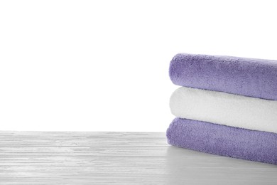 Fresh towels on wooden table against white background. Space for text