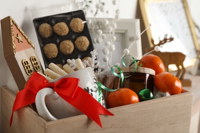 Photo of Crate with gift set and Christmas decor on shelf, closeup