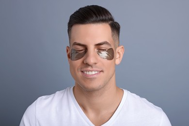 Photo of Man with dark under eye patches on grey  background