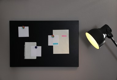 Photo of Many notes attached to magnetic black board on grey wall