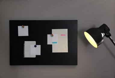 Many notes attached to magnetic black board on grey wall