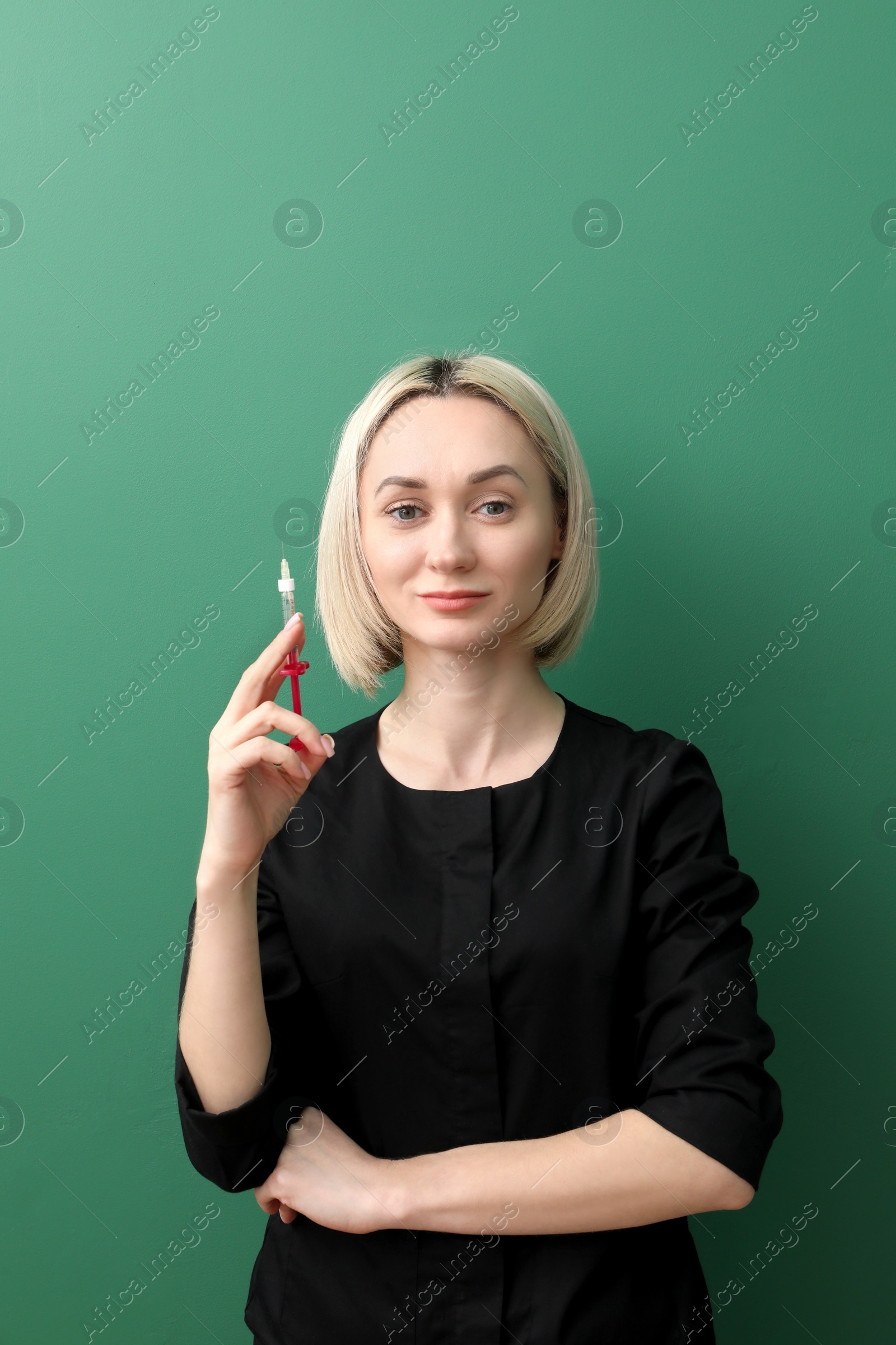 Photo of Portrait of cosmetologist with syringe on green background