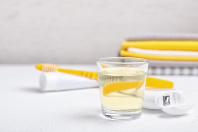 Photo of Glass with mouthwash on table. Teeth care