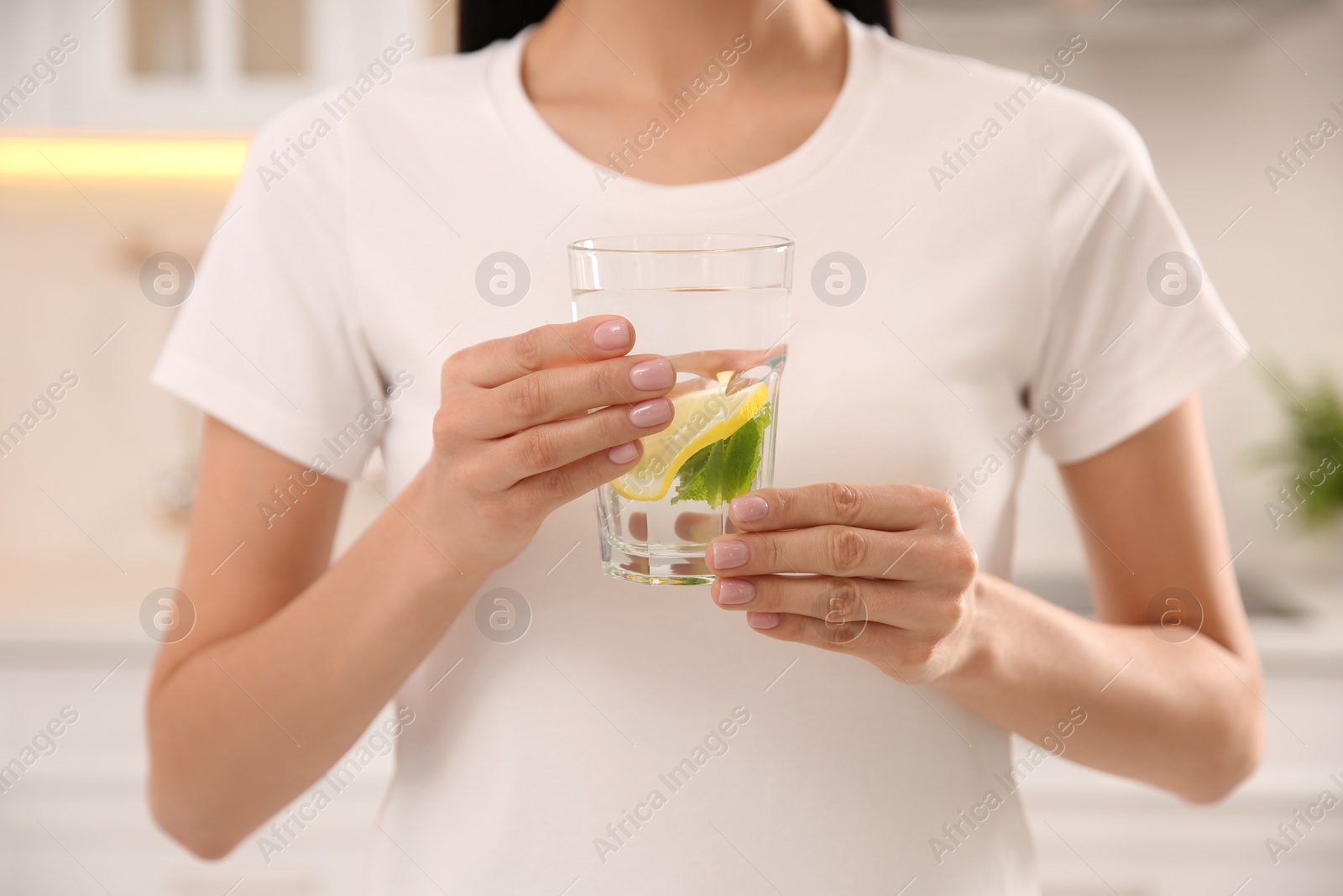 Photo of Young woman with glass of fresh lemonade at home, closeup