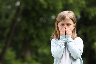 Little girl suffering from seasonal spring allergy outdoors, space for text