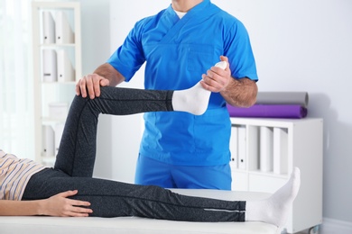 Photo of Doctor working with patient in hospital, closeup. Rehabilitation physiotherapy