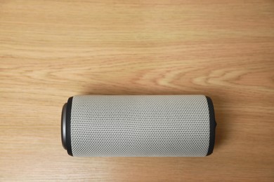 Photo of One portable bluetooth speaker on wooden table, top view with space for text. Audio equipment
