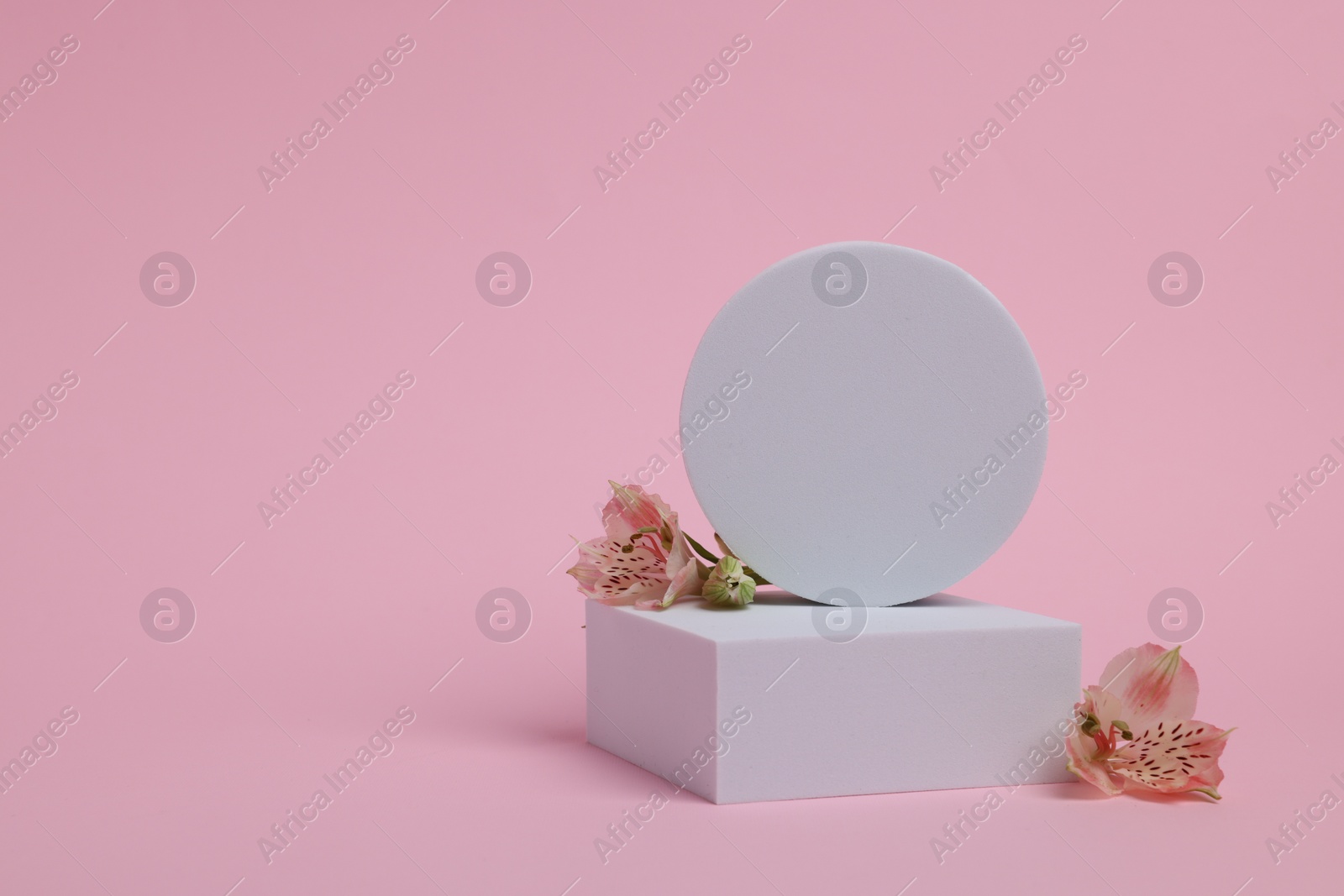 Photo of Scene with podium for product presentation. Figures of different geometric shapes and flowers on pink background, space for text