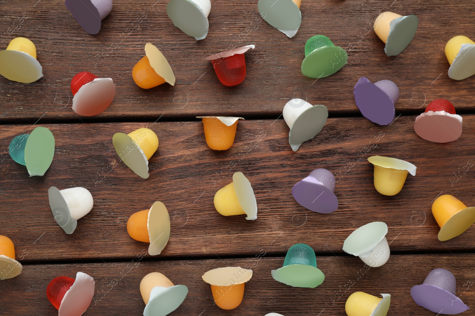 Photo of Tasty bright jelly cups on wooden table, flat lay