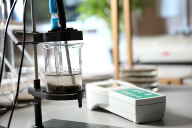 Photo of Measuring acidity and pH of soil on table. Laboratory analysis