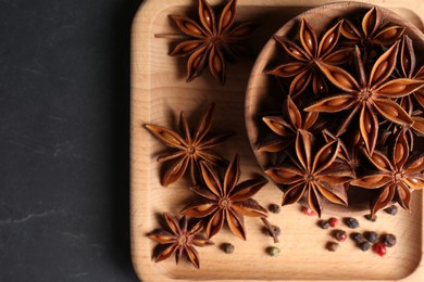 Photo of Aromatic anise stars and spices on wooden board, top view