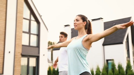 Photo of Sporty couple doing exercise on backyard. Healthy lifestyle