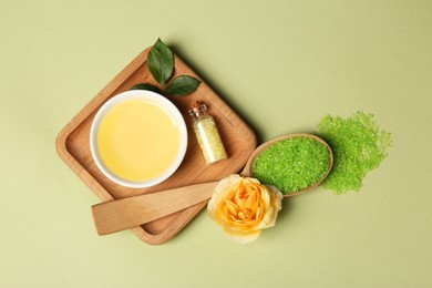 Photo of Flat lay composition with aromatic sea salt and beautiful flower on pale green background